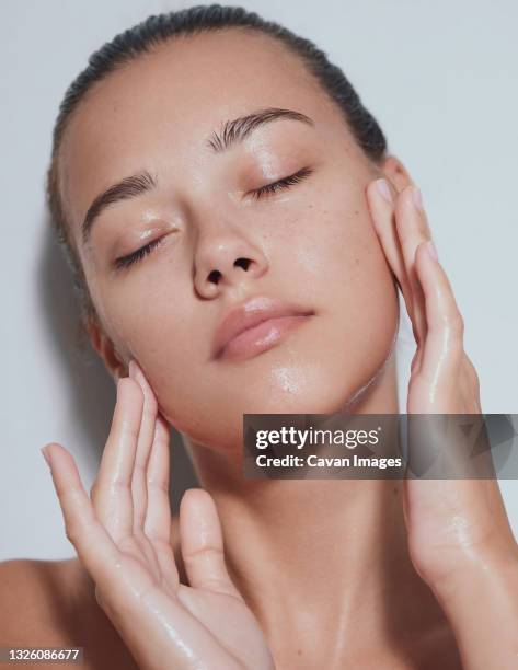 young beautiful woman with clean fresh skin with splash of water - white background - soin photos et images de collection