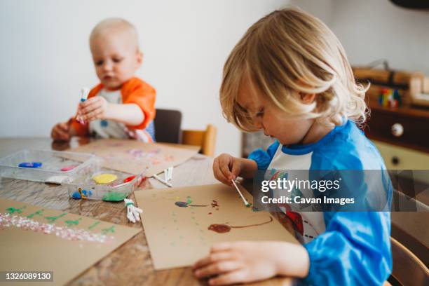 young kids painting with lots of colorful paints at home in lockdown - kids arts and crafts stock pictures, royalty-free photos & images