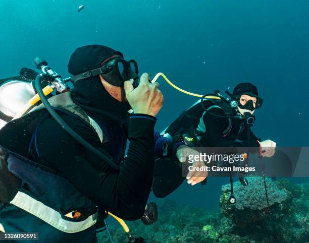 divers sharing air in emergency training in raja ampat / indonesia - aqualung diving equipment stock pictures, royalty-free photos & images