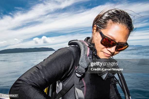 woman getting ready for a dive in raja ampat / indonesia - dive adventure foto e immagini stock