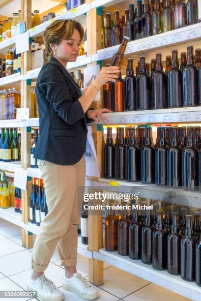 ein junger kunde wählt ein bier aus einem regal in einem lebensmittelgeschäft - buying beer stock-fotos und bilder