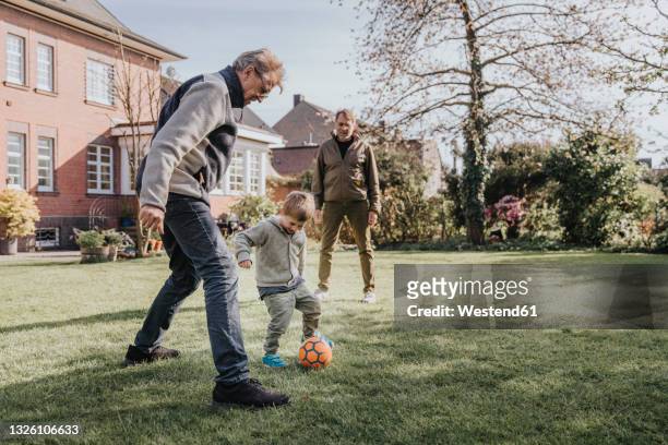 family playing soccer in backyard - backyard football stock-fotos und bilder