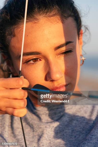 young determined woman practicing archery - bow and arrow stock pictures, royalty-free photos & images