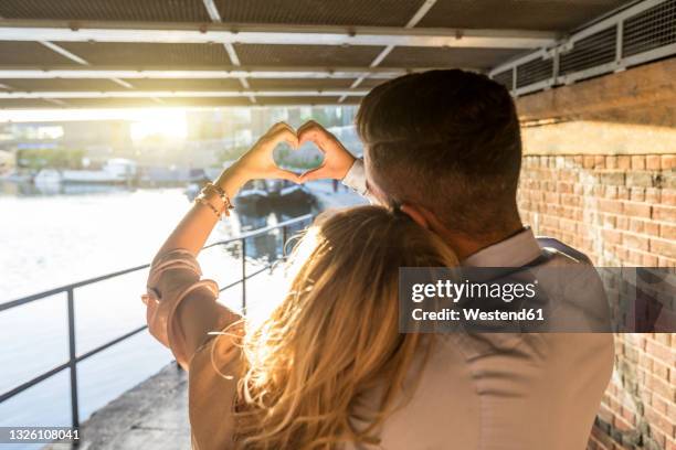 romantic couple making heart shape with hands during sunset - love symbol #2 stock pictures, royalty-free photos & images