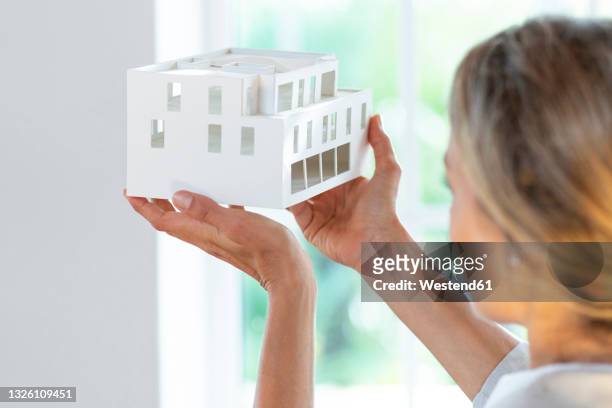 female architect holding architectural model in office - architekturmodell stock-fotos und bilder