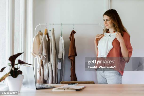 businesswoman showing crop top during video call through laptop at home - crop top stock pictures, royalty-free photos & images