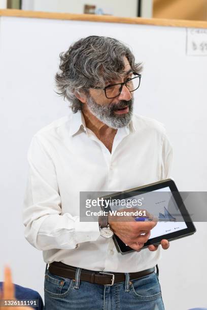 businessman explaining business strategy on digital tablet at office - fotografia de três quartos imagens e fotografias de stock