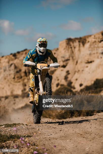 sportsman riding enduro motorcycle on dirt road - motocross photos et images de collection
