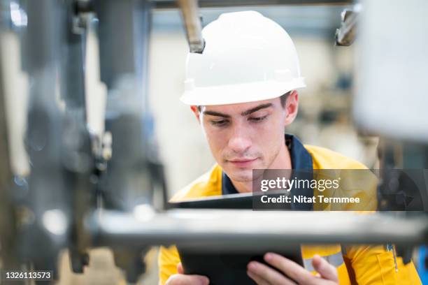 production control engineer using a digital tablet is randomly checking the inventory of car seat chassis parts finishes product on shelf rack for supply to customer in a factory warehouse. - car assembly line control stock pictures, royalty-free photos & images