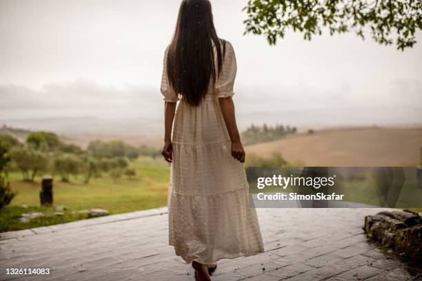 rear view of a woman walking - rain garden stock pictures, royalty-free photos & images