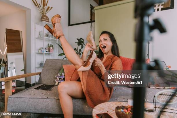 woman showing high heels while vlogging at home - hoher absatz stock-fotos und bilder