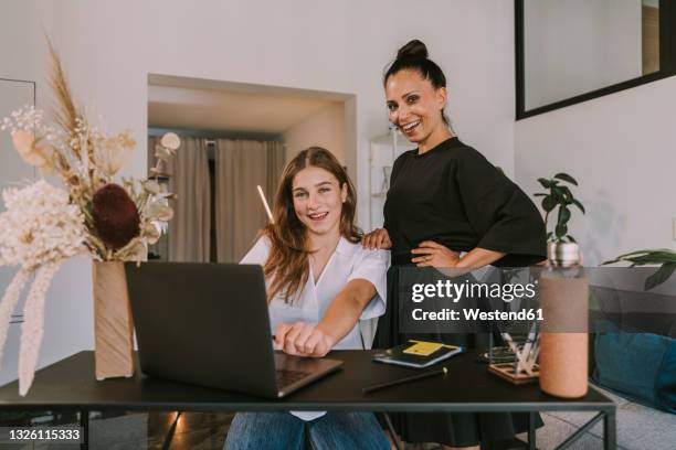 businesswomen working on laptop at desk in office - girl business photos et images de collection