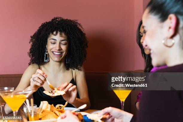 smiling woman having appetizer with friends in restaurant - black tie dinner stock-fotos und bilder