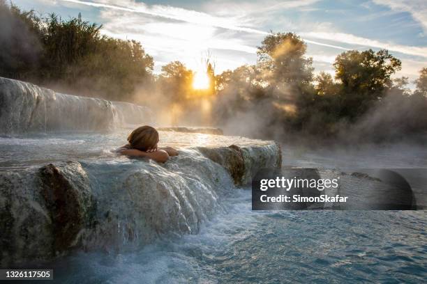 giovane donna che si rilassa alle terme naturali, saturnia, toscana, italia - sorgente di acqua calda foto e immagini stock