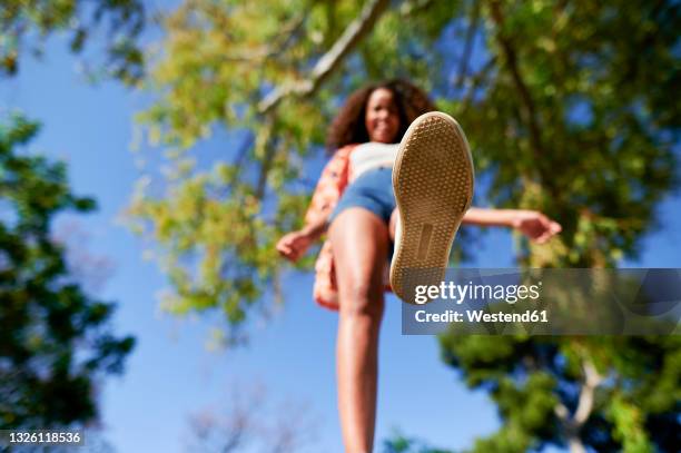 woman walking in park on sunny day - low angle view shoe stock pictures, royalty-free photos & images
