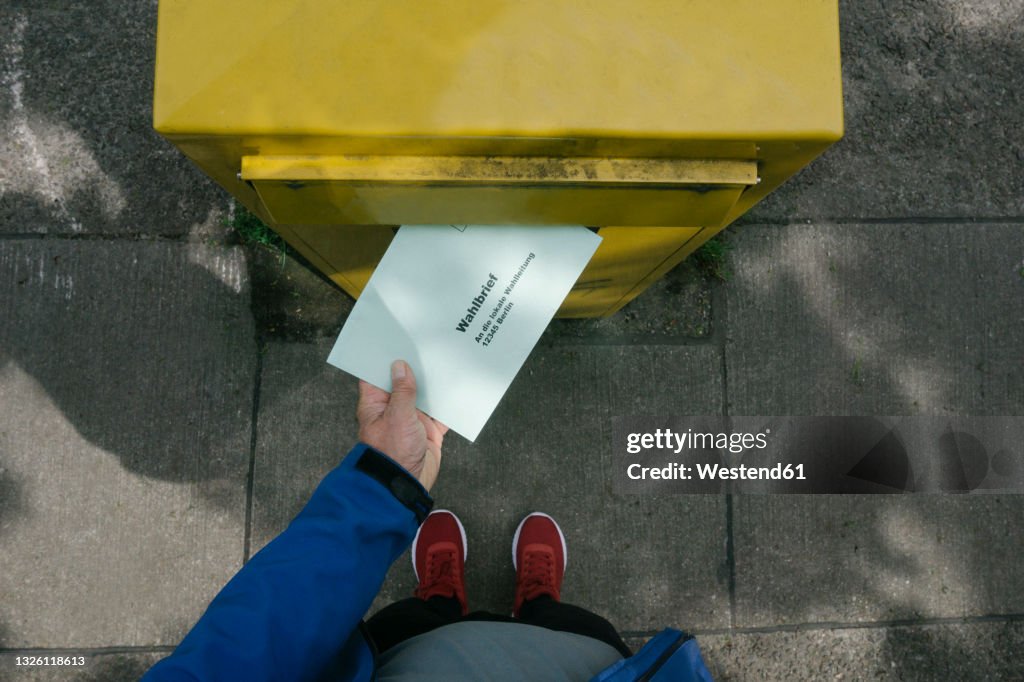 Man putting ballot letter in mailbox