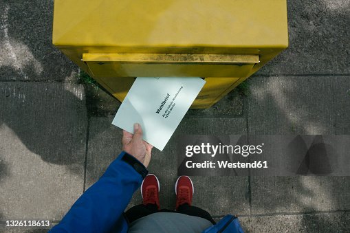 Man putting ballot letter in mailbox Man putting ballot letter in mailbox