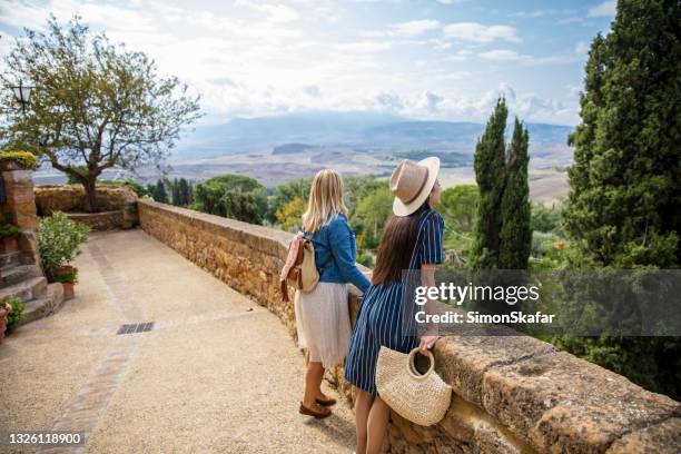 touristenfrauen, die die aussicht bewundern - pienza stock-fotos und bilder