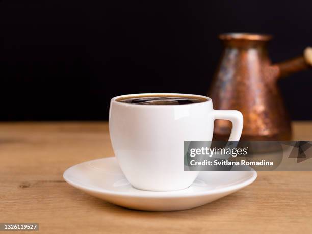 food background with cup of coffee and cezve on wooden table - black cup saucer stock pictures, royalty-free photos & images
