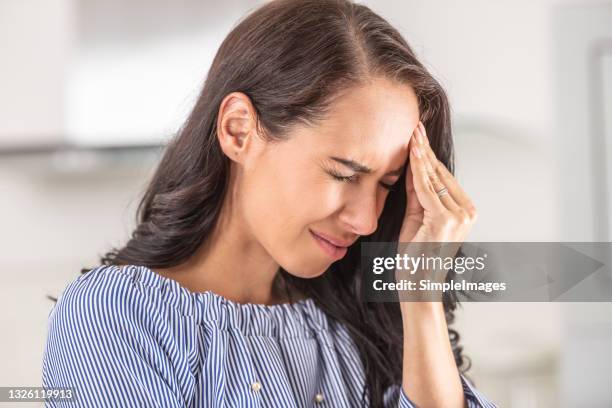 woman suffering from severe headache touches her temple. - vertigo stock pictures, royalty-free photos & images