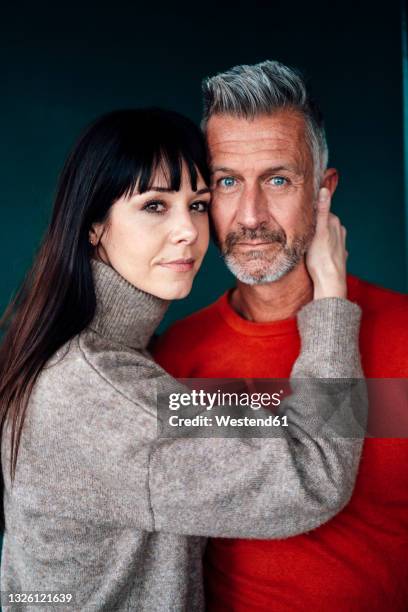 woman with arm around on man standing against green background - straight hair ストックフォトと画像