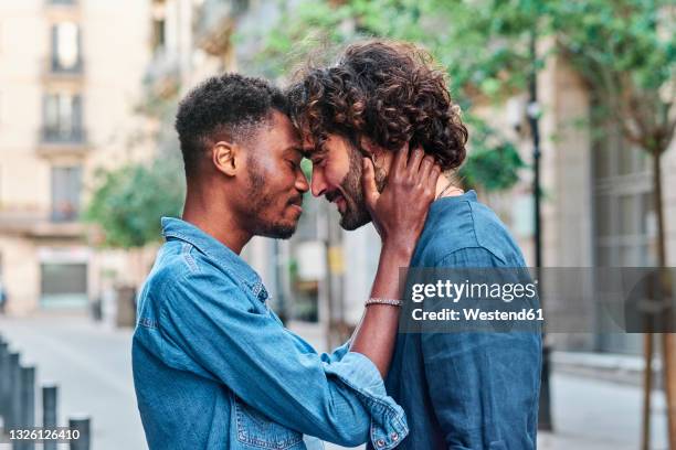 affectionate gay man and boyfriend with eyes closed - affectionate stock pictures, royalty-free photos & images