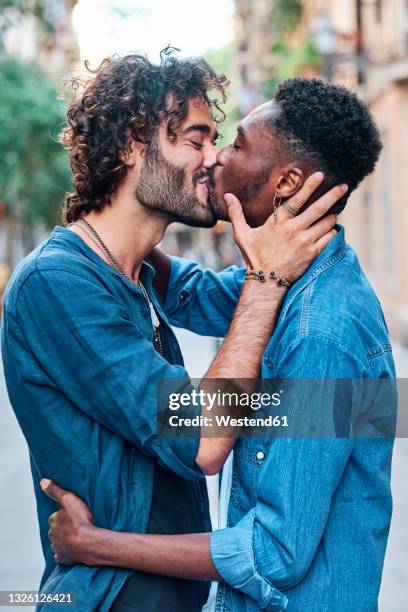 gay couple with eyes closed kissing each other - kissing mouth stock pictures, royalty-free photos & images