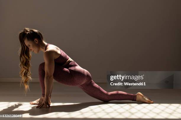 flexible female athlete stretching in exercise room - lunge imagens e fotografias de stock