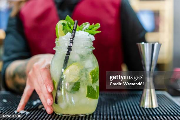 bartender with cocktail jar at bar - caipirinha stock pictures, royalty-free photos & images