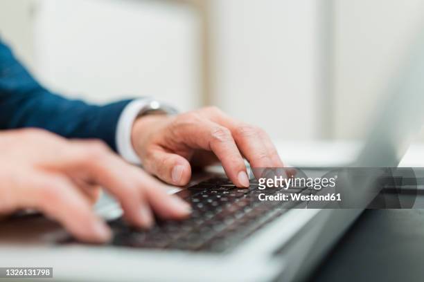 male entrepreneur using laptop at office - typing stock-fotos und bilder