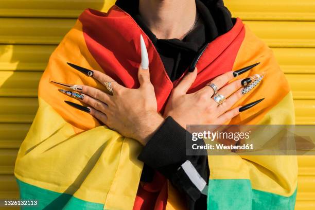 gay man wrapped in rainbow flag - manicura de diseño fotografías e imágenes de stock