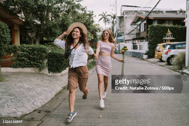 two lesbians walking down the street holding hands,chiang mai,thailand - chiang mai province stock pictures, royalty-free photos & images