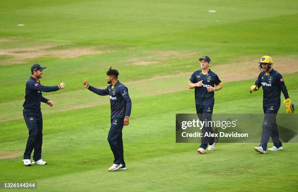Prem Sisodiya of Glamorgan celebrates the wicket of Jamie Overton of Surrey with Colin Ingram during the Vitality T20 Blast match between Glamorgan...