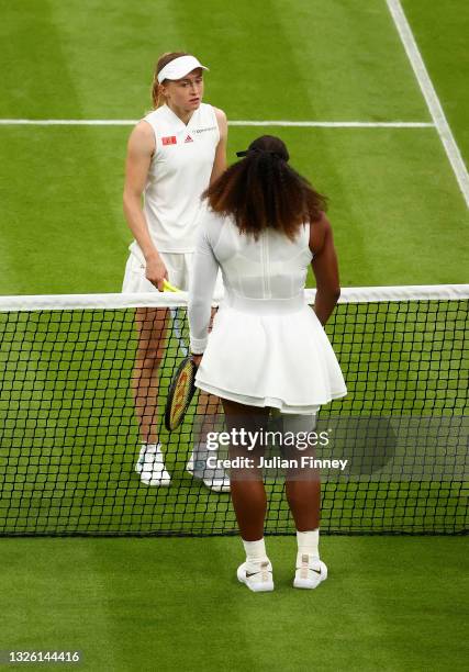 Aliaksandra Sasnovich of Belarus interacts with Serena Williams of The United States at the net after Serena Williams retired from the match with an...