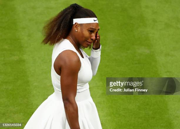 Serena Williams of The United States reacts in pain as she prepares to serve in her Ladies' Singles First Round match against Aliaksandra Sasnovich...