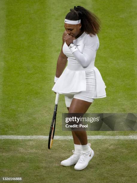 Serena Williams of The United States reacts in pain as she prepares to serve in her Ladies' Singles First Round match against Aliaksandra Sasnovich...