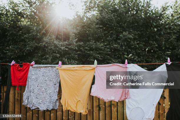 damp clothing hanging on a washing line - launderette stockfoto's en -beelden