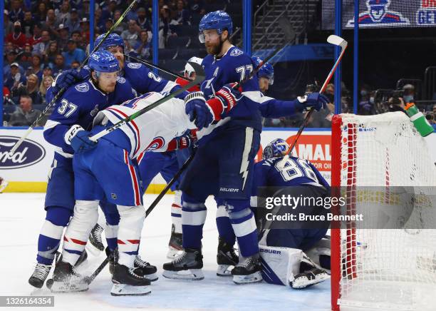 Brendan Gallagher of the Montreal Canadiens is held up by the Tampa Bay Lightning during Game One of the 2021 NHL Stanley Cup Finals against the...