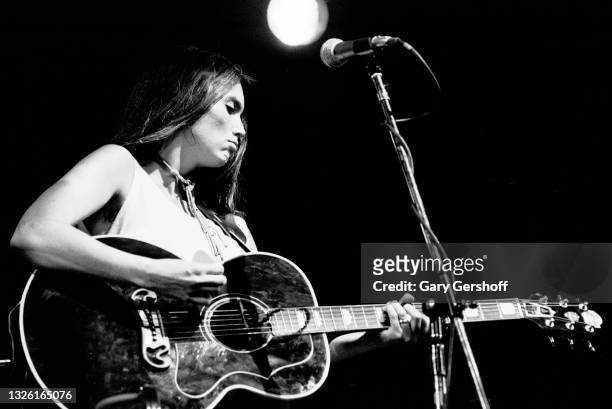 American Country musician Emmylou Harris plays acoustic guitar as she performs onstage during the Dr Pepper Central Park Music Festival, New York,...