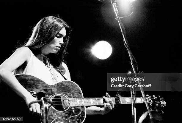 American Country musician Emmylou Harris plays acoustic guitar as she performs onstage during the Dr Pepper Central Park Music Festival, New York,...