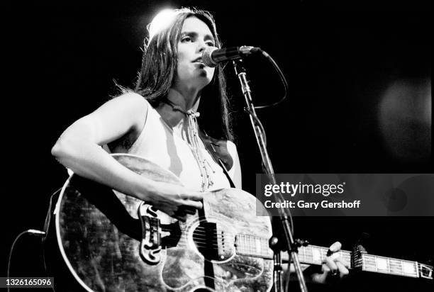American Country musician Emmylou Harris plays acoustic guitar as she performs onstage during the Dr Pepper Central Park Music Festival, New York,...