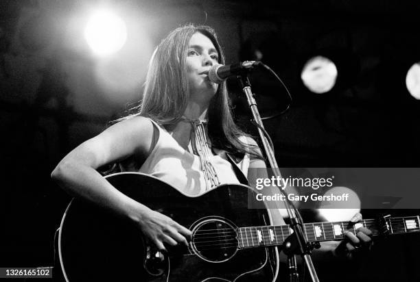 American Country musician Emmylou Harris plays acoustic guitar as she performs onstage during the Dr Pepper Central Park Music Festival, New York,...