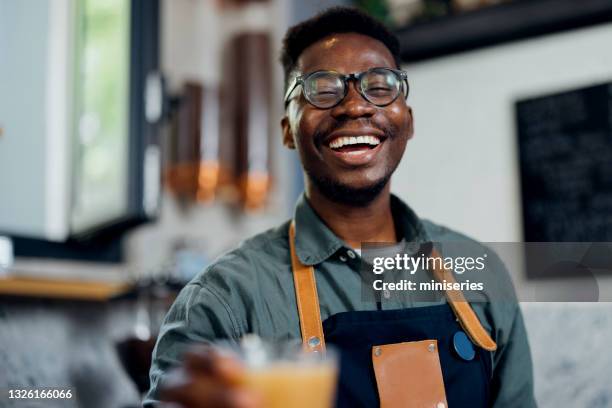ritratto di cameriere sorridente che serve caffè freddo in una caffetteria - barista foto e immagini stock