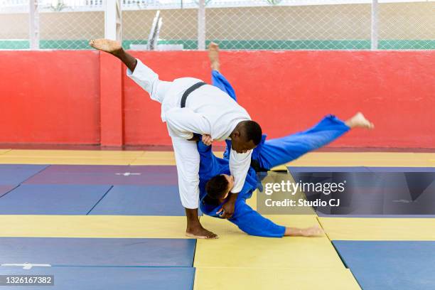 judo athlete entering blow during fight - judo stock pictures, royalty-free photos & images