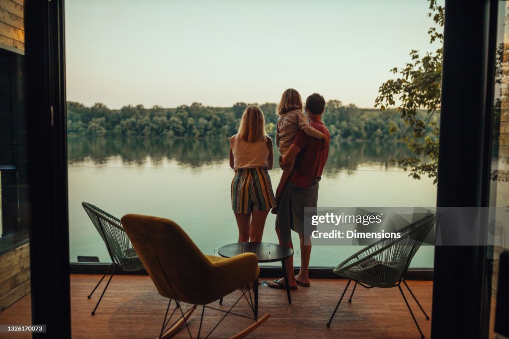 Adorable family of three at the terrace looking at the river