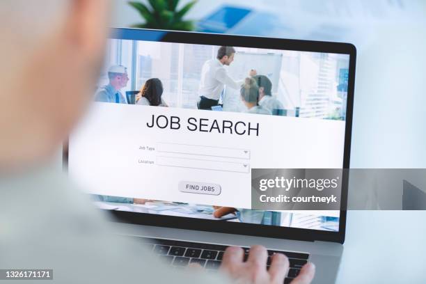reife geschäftsmann blick auf job-suche website auf einem laptop-computer. - vacancy stock-fotos und bilder