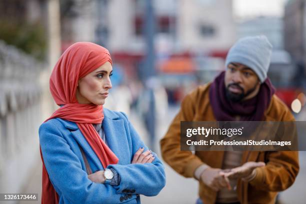 a displeased couple is walking in the city streets and discussing the problems they have. - annoying colleague stock pictures, royalty-free photos & images