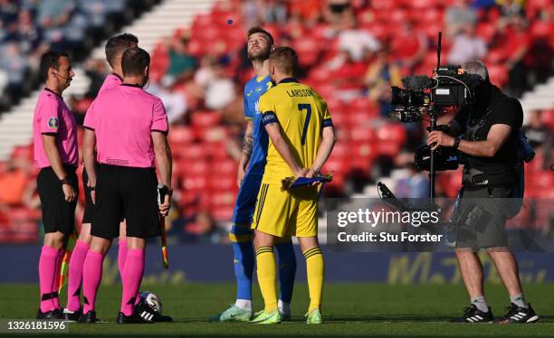 Ukraine captain Andriy Yarolenko watches the tossed coin as Sweden captain Sebastian Larsson and the match officials look on during the UEFA Euro...