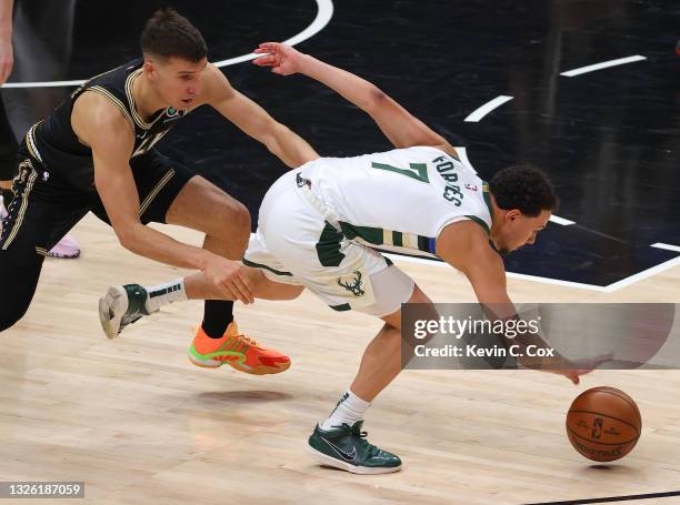 Bryn Forbes of the Milwaukee Bucks looses the ball against Bogdan Bogdanovic of the Atlanta Hawks during the first half in Game Four of the Eastern...