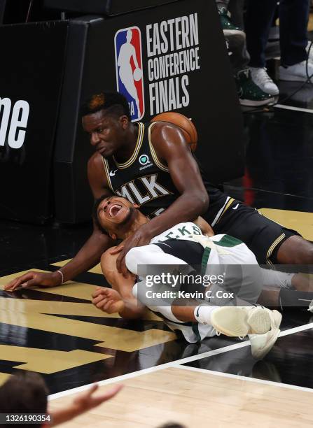 Giannis Antetokounmpo of the Milwaukee Bucks is injured on a play against Clint Capela of the Atlanta Hawks during the second half in Game Four of...